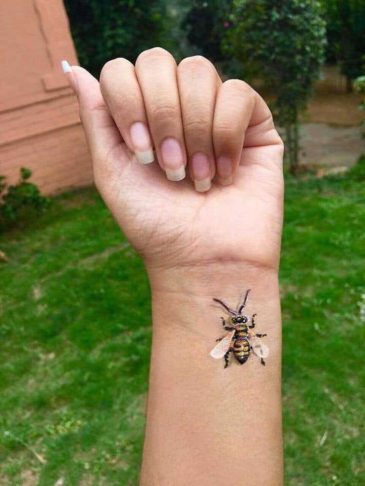 PAinting of a bee on a wrist